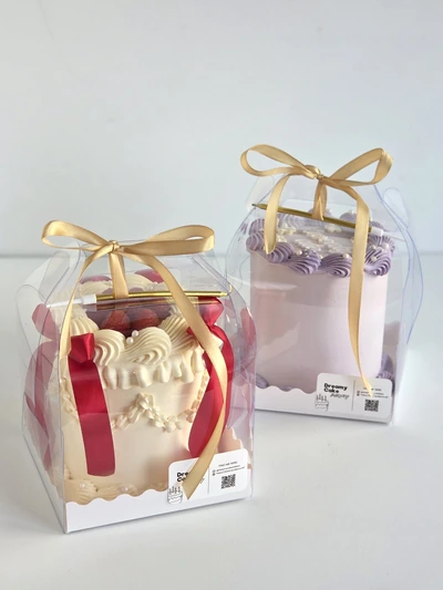 Mini celebration cakes in clear gift boxes with ribbon bows