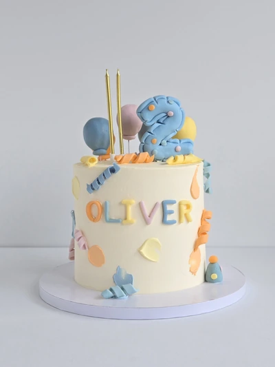 Pastel second birthday cake with personalised name and number topper