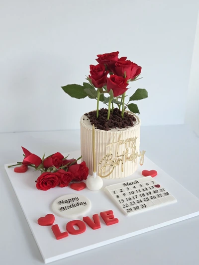 Romantic celebration cake with red roses, calendar plaque and LOVE lettering