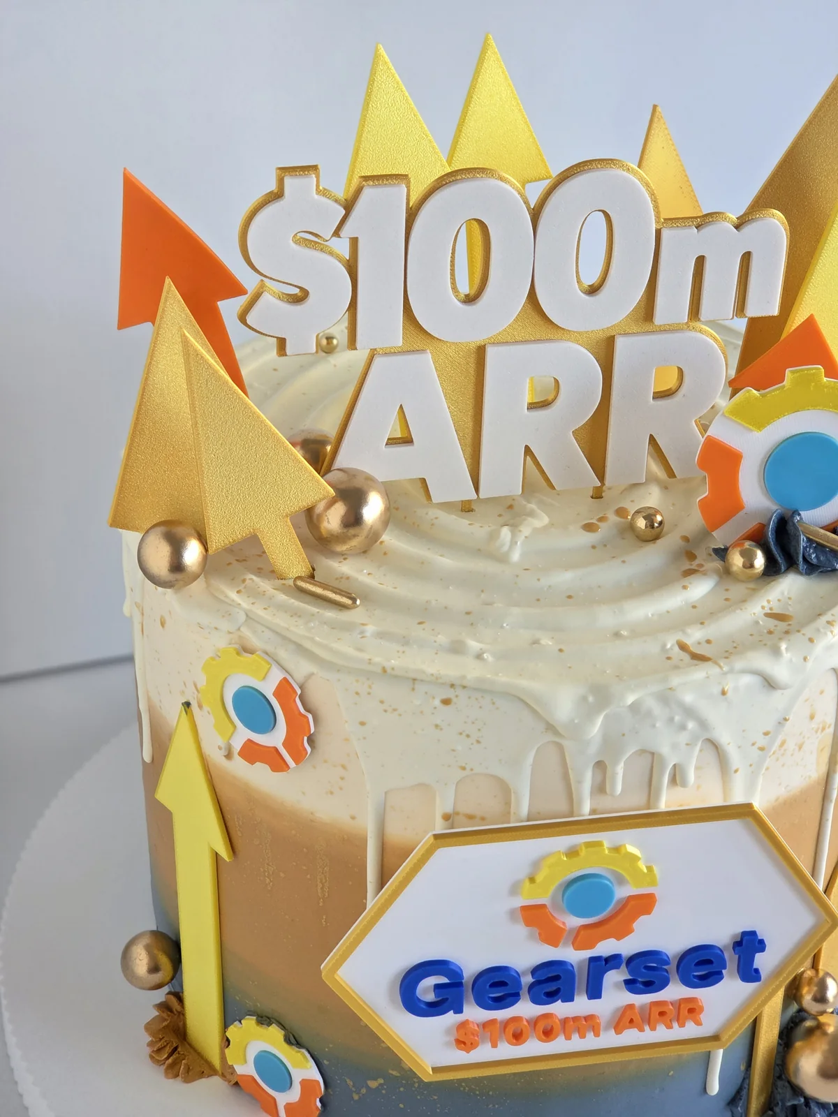 Close-up of a Gearset corporate cake with a 100 million dollar ARR topper for a Cambridge company milestone