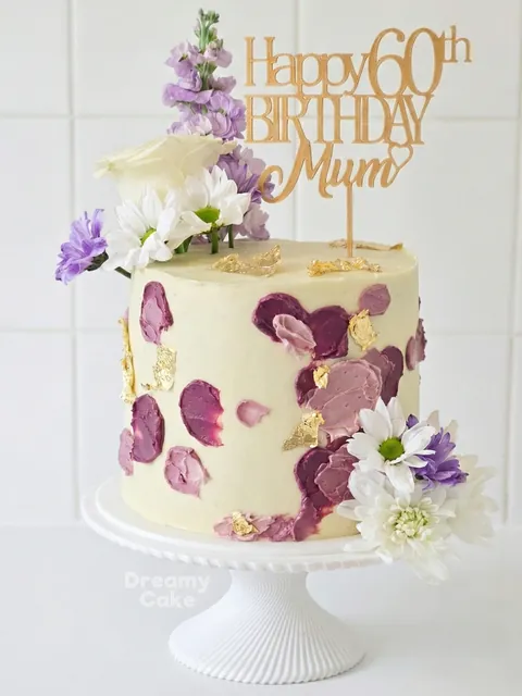 Floral 60th birthday cake with hand-painted blossoms and topper