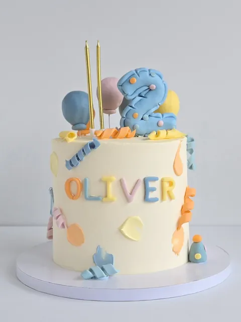 Birthday cake with blue elephant topper, balloons and Oliver name detail