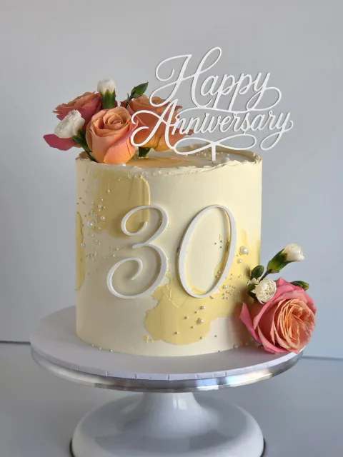 Ivory 30th anniversary cake decorated with fresh peach and pink roses