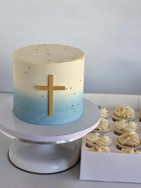 Blue ombre christening cake with gold cross and matching cupcakes