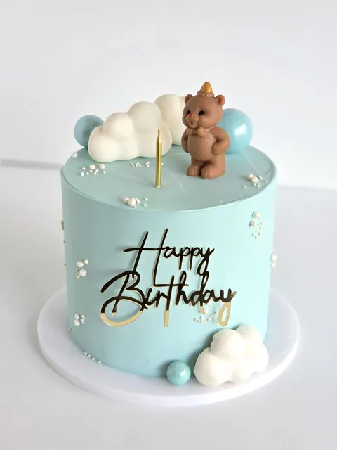 Blue celebration cake with teddy bear topper
