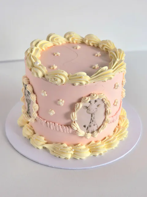 Pink vintage-piped celebration cake with framed giraffe illustrations