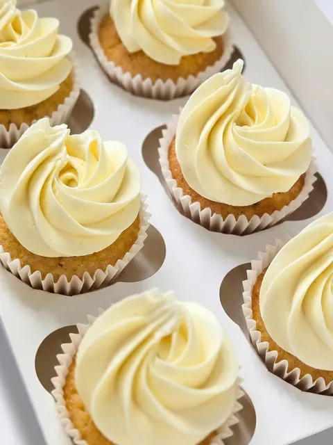 Vanilla cupcakes with classic buttercream swirls in a box