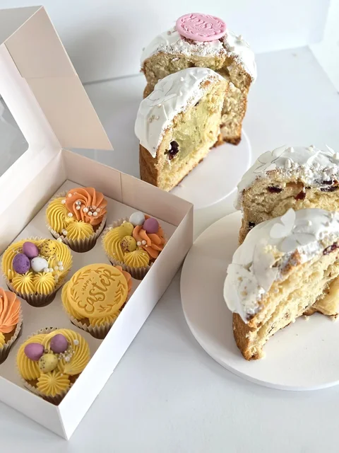 Traditional Easter Paska and spring cupcakes presented together in a pastel gift box
