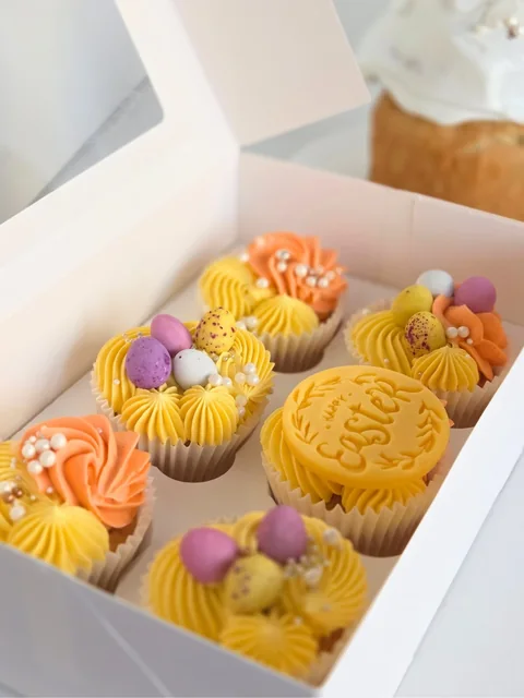 Close-up of spring Easter cupcakes in a pastel gift box with mini egg decorations