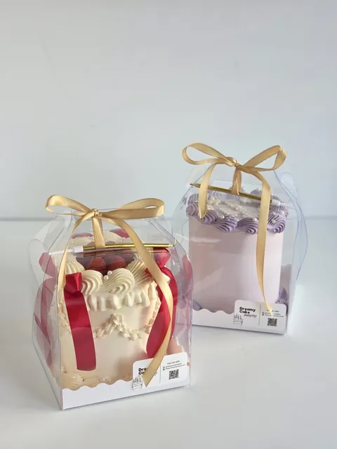 Two mini bento cakes packaged in clear gift boxes with ribbon bows