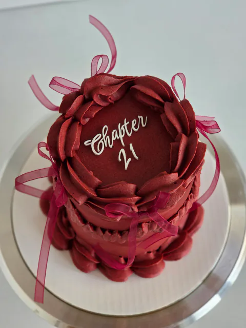 Burgundy heart-shaped mini cake with vintage piping, ribbon bows and Chapter 21 message