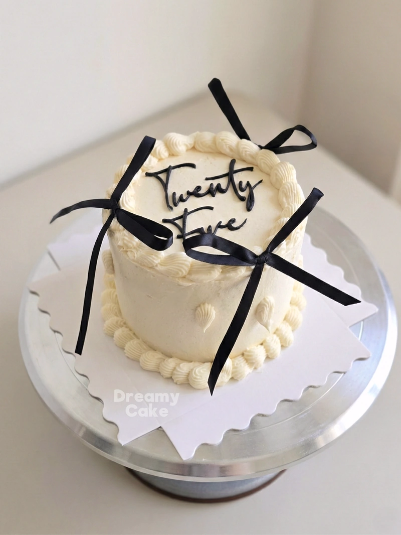 White mini bento cake with black ribbon bows