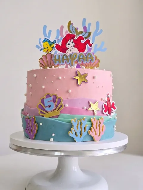 Under-the-sea themed birthday cake with mermaid topper, coral and shells