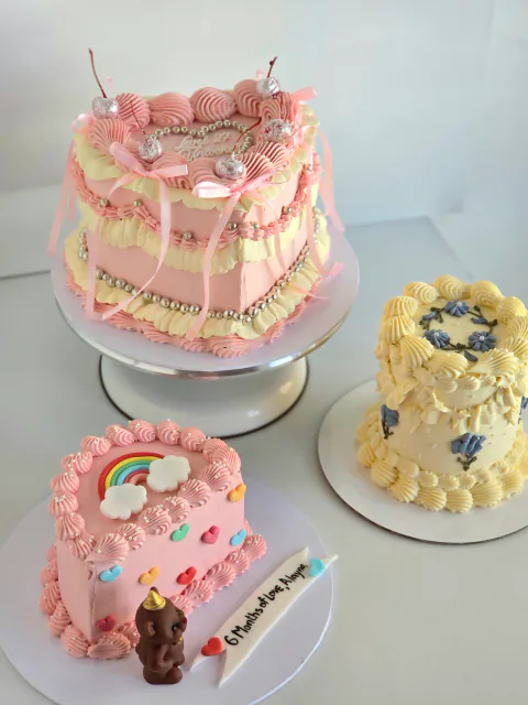 Trio of children's mini cakes with rainbow, floral and ribbon bow designs