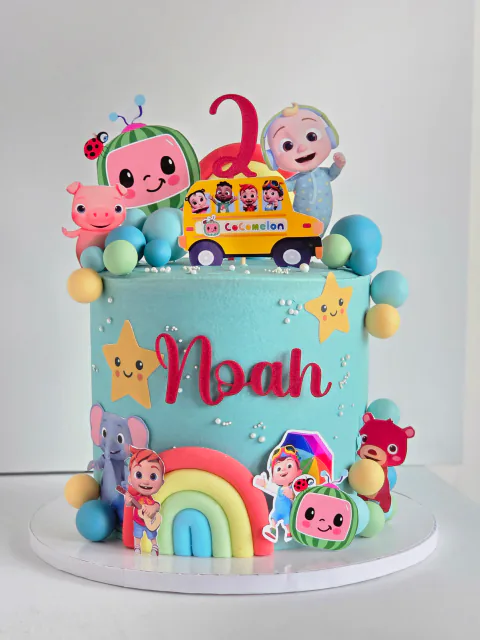 Colourful Cocomelon-inspired birthday cake with rainbow and character decorations