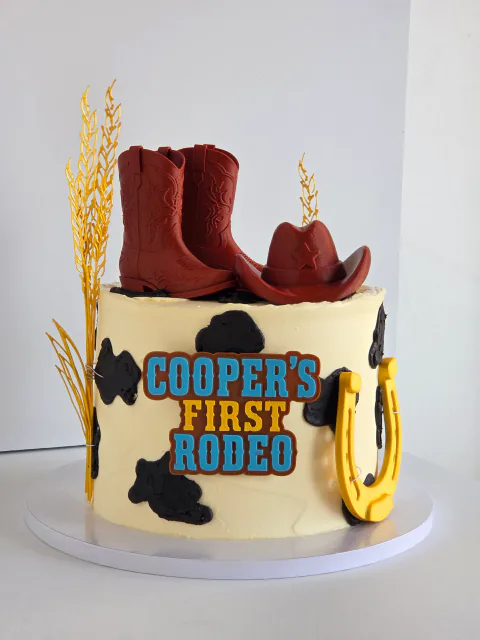 Western cowboy first birthday cake with Cooper's First Rodeo message