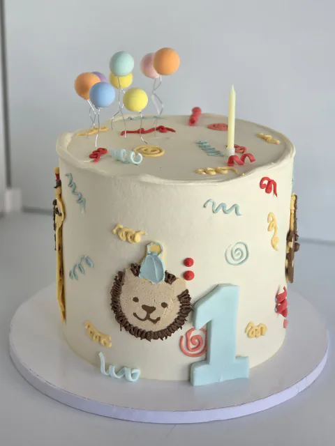 First birthday cake with teddy bear, balloons and personalised name plaque