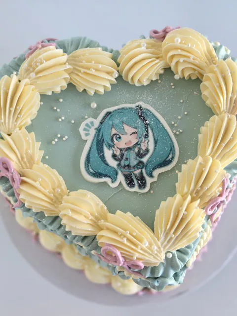 Heart-shaped Hatsune Miku anime cake with blue vintage piping