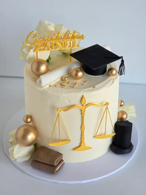 Law graduation cake with scales of justice, books and graduation cap