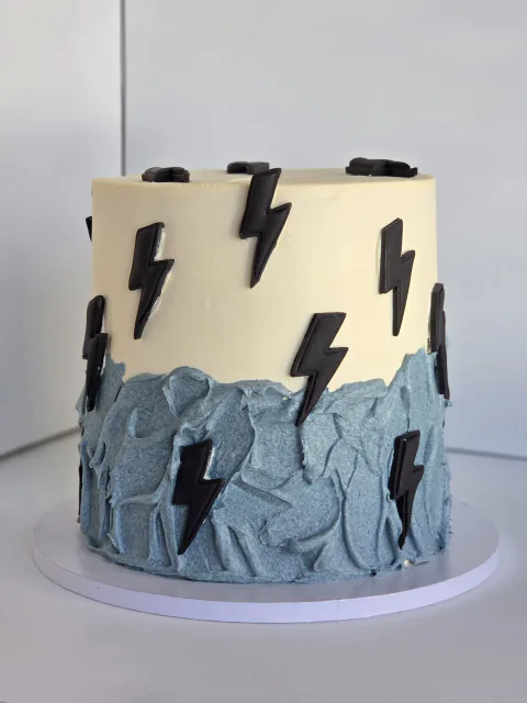 Cream and steel-blue rock-textured cake with black lightning bolts