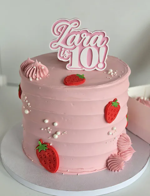 Pink strawberry-themed tenth birthday cake personalised for Lara