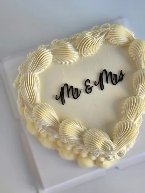 Cream heart-shaped wedding cake with black Mr and Mrs lettering