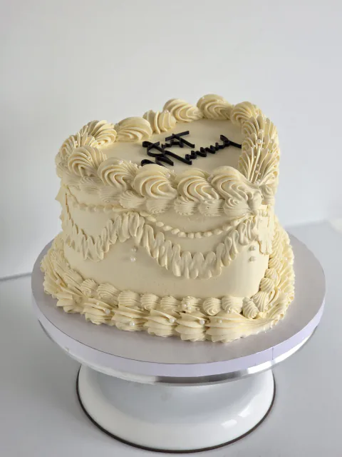 White heart-shaped wedding cake with Lambeth piping and black Mr and Mrs lettering