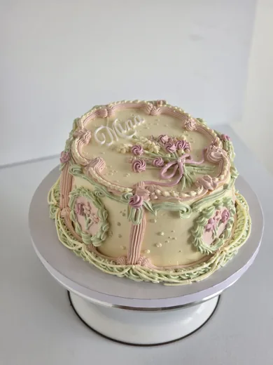 Pastel vintage buttercream cake with piped flowers and ribbon details