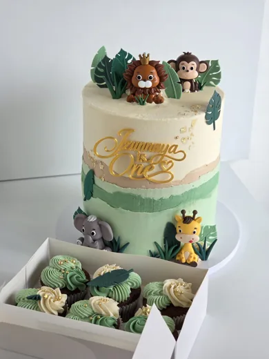 Jungle-themed first birthday cake with matching cupcakes